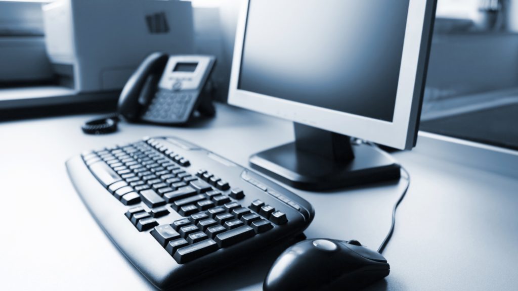 modern office setup with flat-screen monitor, keyboard, and desk phone for efficient it communication.