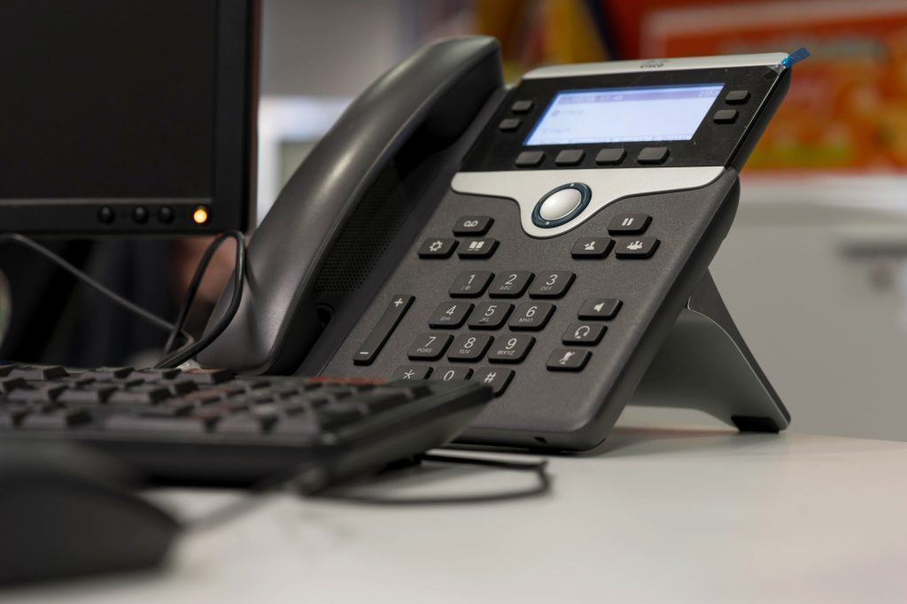 modern office setup showcasing a sleek phone and a black keyboard for efficient communication.