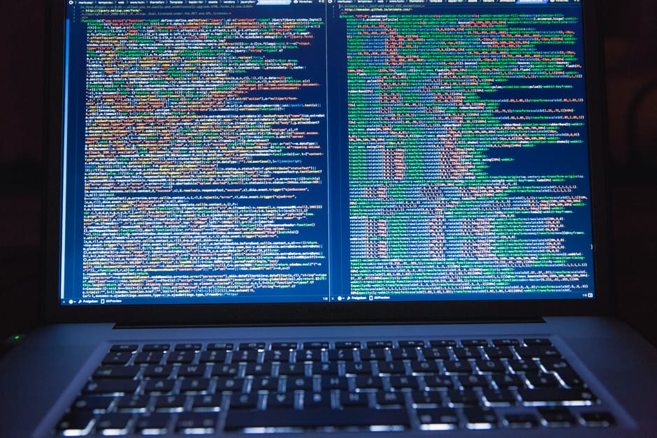 close-up of a laptop displaying vibrant code, highlighting a programmers focused workspace.