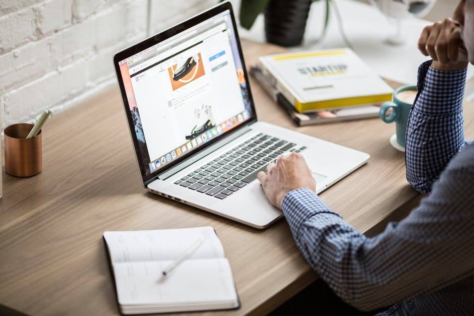 modern workspace with a laptop, notebook, books, and plant, fostering productivity and creativity.