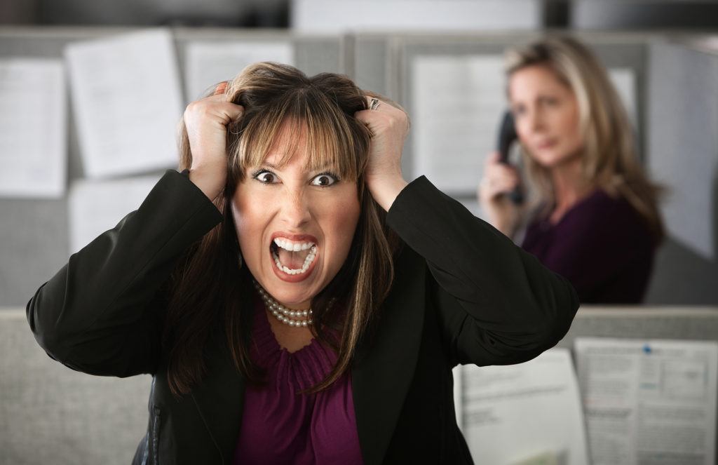 a woman in an office holding her head