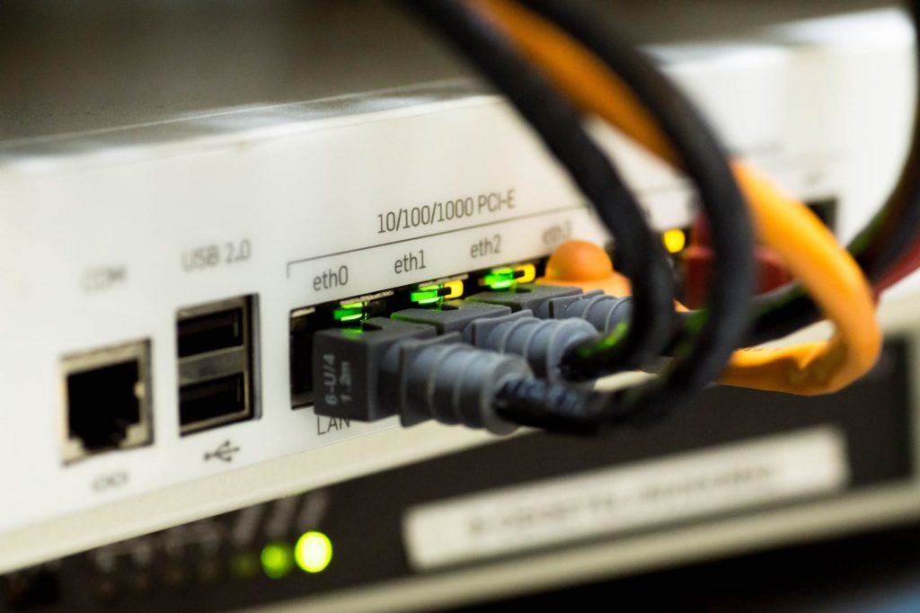 close-up of a network switch with ethernet ports and organized, color-coded cables.