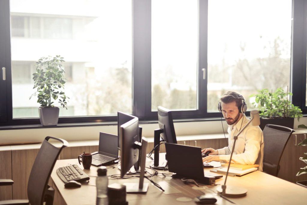 a man sitting at a desk in front of a laptop computer