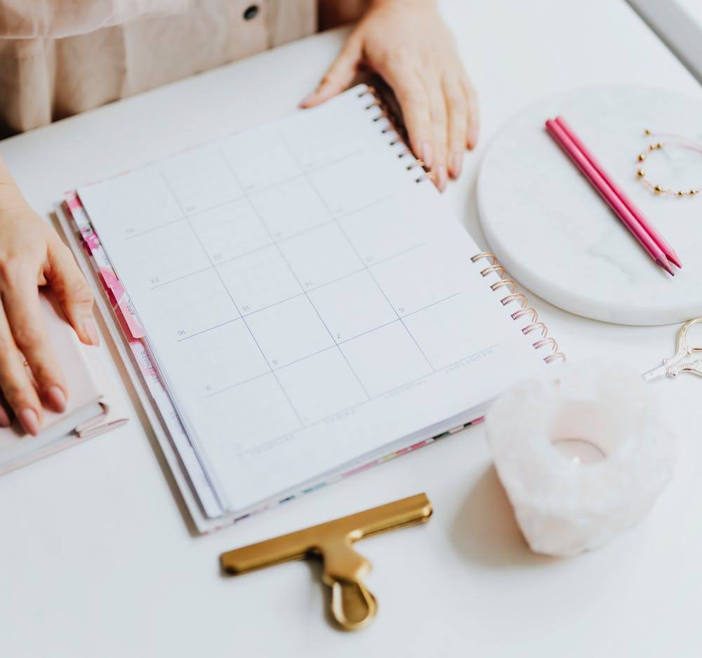 a woman sitting at a desk with a planner