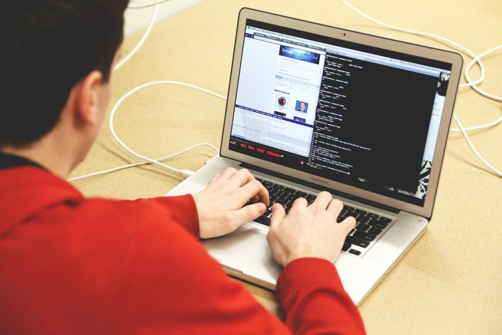 a man sitting at a table using a laptop computer