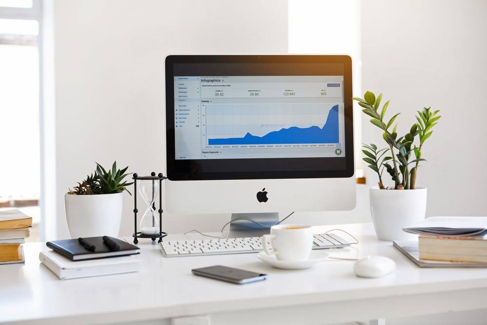 modern workspace with imac, plants, and books, fostering productivity and business growth.