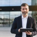 a man in a suit holding a tablet