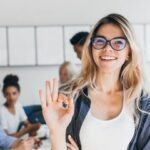 cheerful woman at the forefront, symbolizing positivity amidst a collaborative office team.