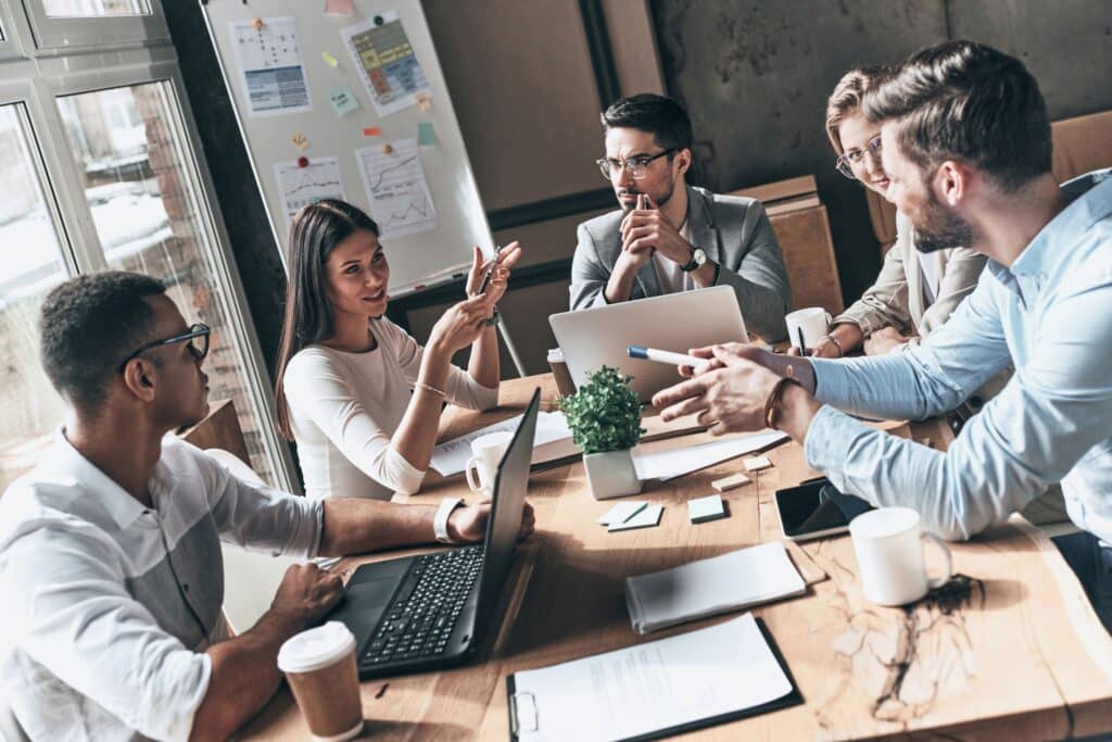 professionals collaborating in a bright office, sharing ideas around a modern conference table.