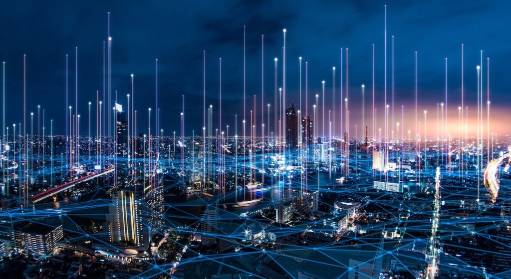 modern cityscape at dusk showcasing illuminated skyscrapers and digital connectivity through light beams.