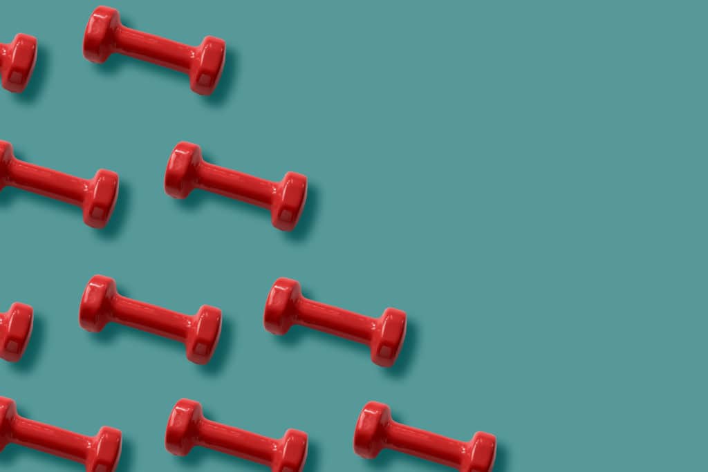 vibrant red dumbbells scattered on a soothing teal background, symbolizing fitness and energy.