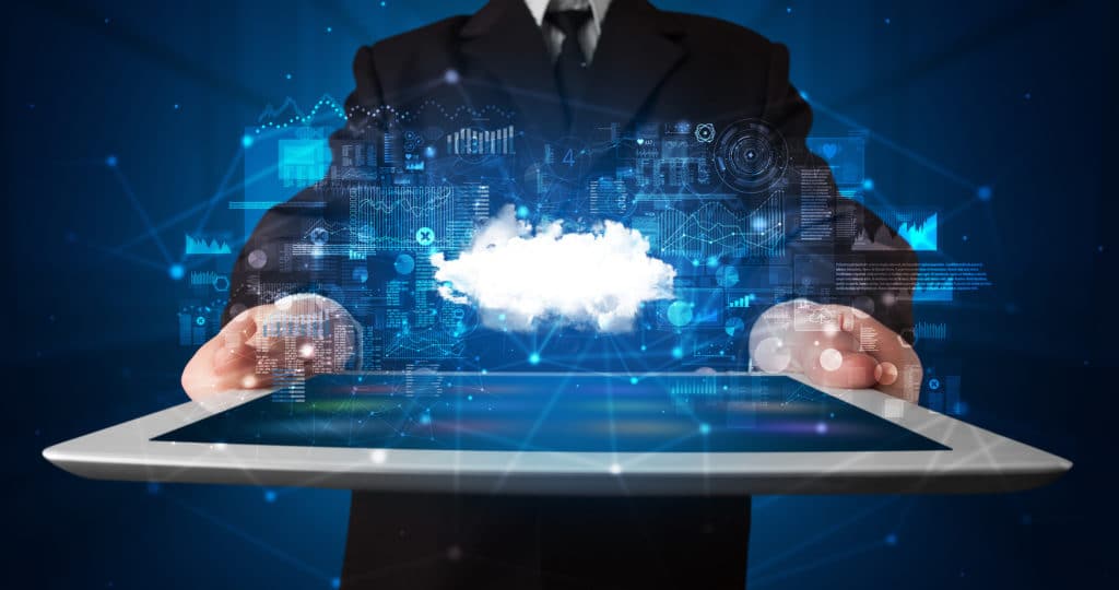 professional in suit showcasing cloud technology on a tablet against a futuristic digital backdrop.