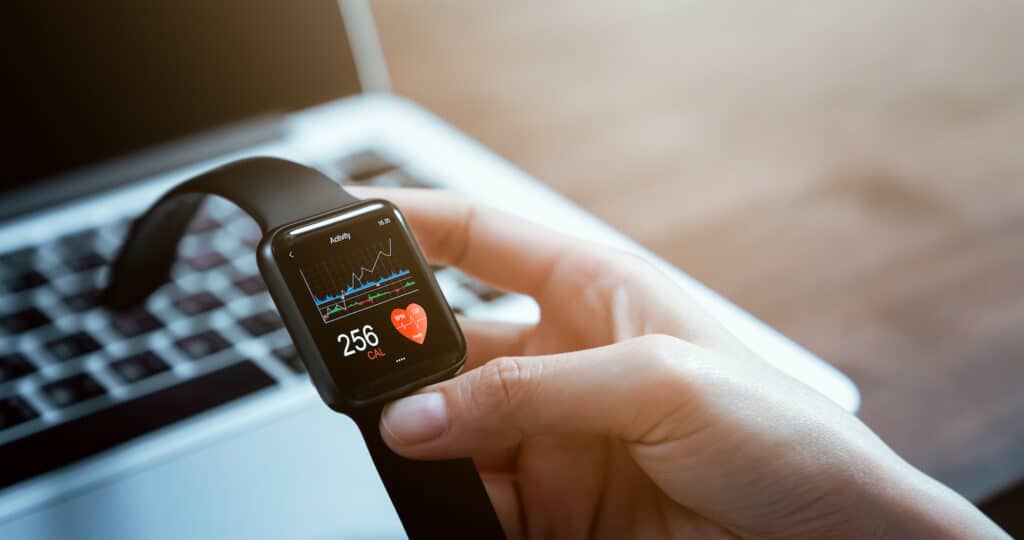 hand interacting with smartwatch displaying health metrics, promoting an active lifestyle and fitness tracking.