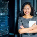 a woman standing in front of a server in a server room