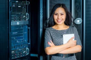 a woman standing in front of a server in a server room